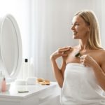 Anti-Aging Skincare. Beautiful Woman Massaging Skin With Greenstone Jade Roller At Home
