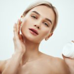 Best moisturizer for your skin type. Portrait of gorgeous young woman spreading cream on her face