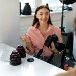 The art of feedback. Young photographer lady showing results of photoshoot to guy, discussing photos